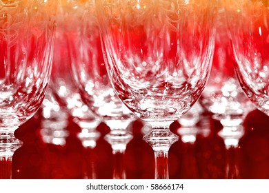 Row Of Empty Wine Glasses In Party Light (focus On The Middle Front One)