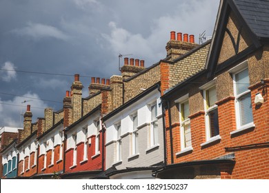 Row of English terraced houses in Crouch End, London, with a cloudy sky