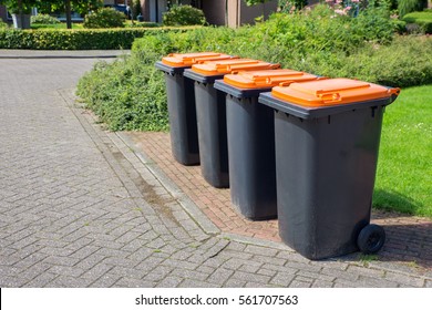 Row of european grey waste bins along street