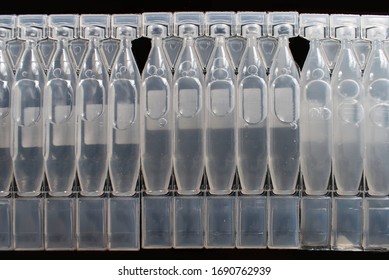 Row Of Eye Drops Blisters Isolated On Black Background.