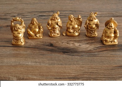 
Row of Figurines of laughing and cheerful golden Buddhas 