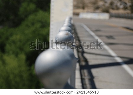 A row of finial balls on top of the steel bridge railing.