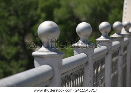 A row of finial balls on top of the steel bridge railing.