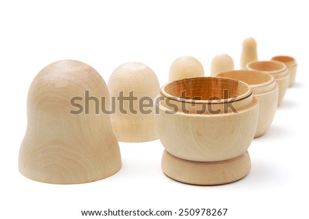 Row of five disassembled wooden matryoshkas on white background