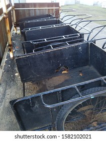 Row Of Four Black Industrial Yard Waste Carts On Wheels