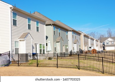 Row Of Generic Houses From Backyard View Showing Yards And Fences In A Southeast U.S. Suburb On A Beautiful Sunny Blue Sky Day.