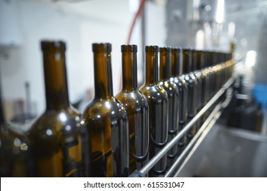 Row of glass wine bottles moving by conveyor