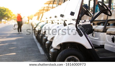 row of golf carts on a golf course. golf course carts cars at luxury resort sport venue in neat line row. 