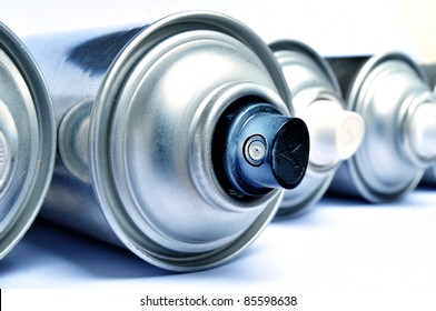Row of graffiti aerosol cans - Blue toned