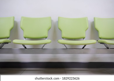 Row Of Green Office Chairs Standing In Corridor Or Conference Room, Empty Dark Seats Arranged In Line In Boardroom, Range Of Basic Stools In Front Of White Wall. Interview, Recruitment Concept