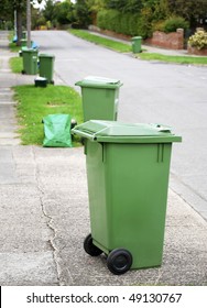 Row Of Green Recycling Bins In Urban Street