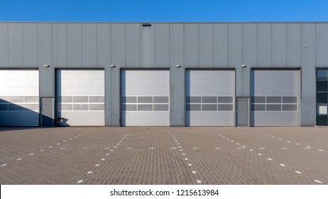 Row Of Grey Industrial Units With Roller Shutter Doors.