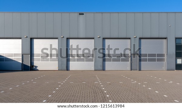 Row\
of grey industrial Units with roller shutter\
doors.