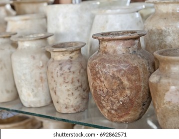 Row of hand crafted alabaster jars and vases on glass shelf at an egyptian market shop stall - Shutterstock ID 692862571