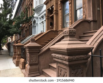A row of Harlem brownstone stoops and entrances