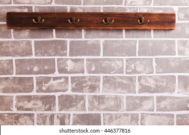 A row of hooks for clothes on the brick wall