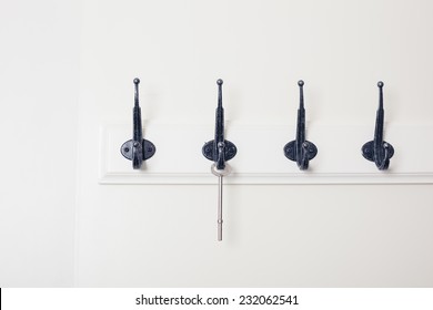 A row of hooks with a key hanging from one of them