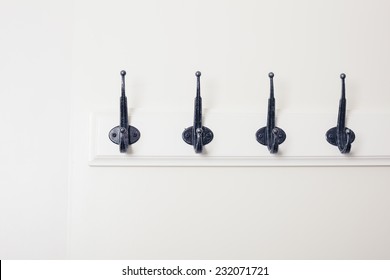 A row of hooks on a white door