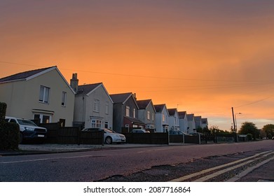 Row Of Houses In A Suburban Street Against A Stunning Orange Sunset Sky