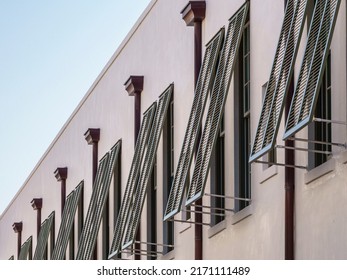 Row Of Hurricane Shutters Along Building Exterior In A Beach Town On The Gulf Coast Of Florida, For Themes Of Safety And Preparedness