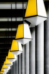 Row Of Identical Yellow Light Fittings Overhead In Colonnade