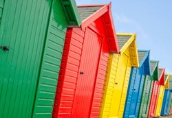 A Row Of Individually Coloured Beach Huts.