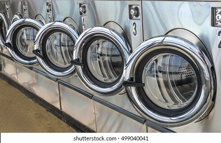 Row Of Industrial Laundry Machines In Laundromat.