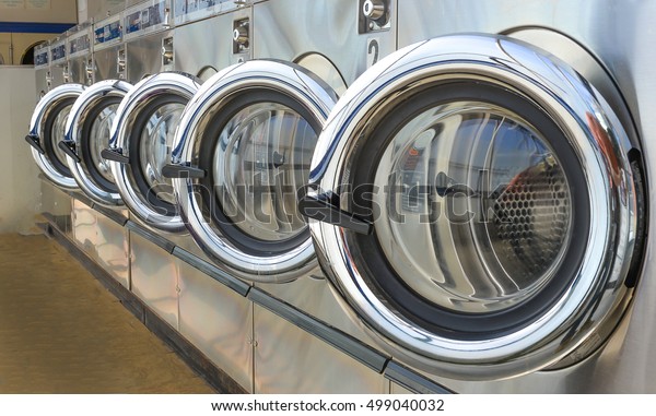 Row of\
industrial laundry machines in\
laundromat.