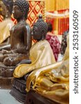 A row of intricately designed Buddhist statues, draped in golden robes, is seen inside a beautifully decorated temple, highlighting the rich cultural heritage and religious significance.