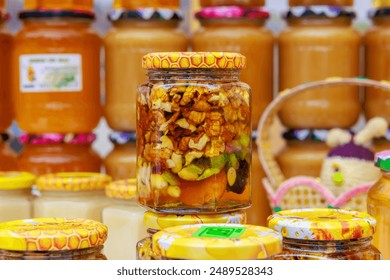 A row of jars filled with various types of food, walnuts in honey