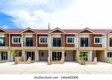 The row of just finished new brown townhouses, Modern village buildings with blue sky, Concept of buying a house vs renting an apartment. - Shutterstock ID 1466682008