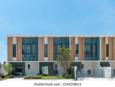 The row of just finished new brown two-floor townhouses, Modern village buildings with blue sky, Concept of buying a house vs renting an apartment.