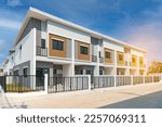 The row of just finished new townhouses, the Concept of buying a house vs renting an apartment,  architectural design exterior townhomes  with blue sky.