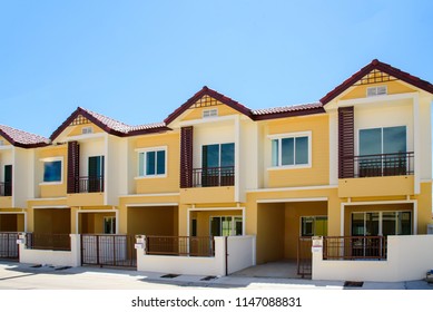 Row of just finished new yellow townhouses. - Shutterstock ID 1147088831