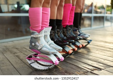 row of kangoo jumping boots at womens legs. group of girls at fitness workout
