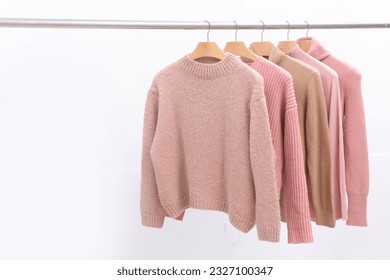 Row of Knitted, turtleneck sweaters hang on hangers. Bright sweaters.. Fashion.