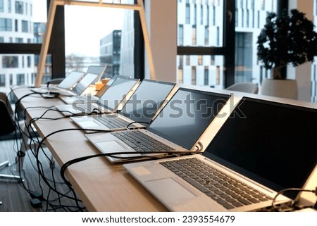 Row of laptops being prepared and set up for new employees in a company