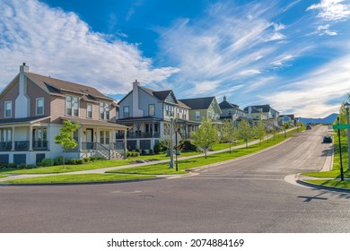 Row of large two-storey houses near the paved uphill road at Daybreak, Utah