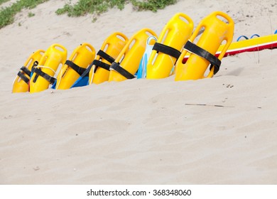 Row of lifesaving and floatation devices lined up on the beach