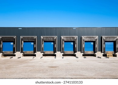 Row of loading docks with shutter doors at an industrial warehouse.