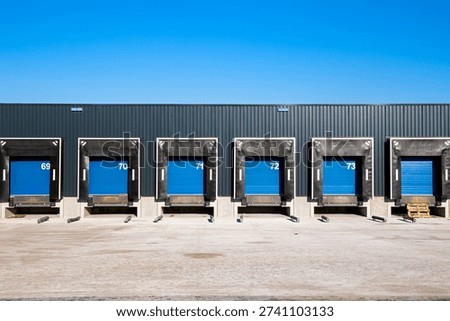 Row of loading docks with shutter doors at an industrial warehouse.