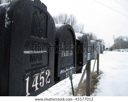 A row of mailboxes covered in snow from a late winter storm