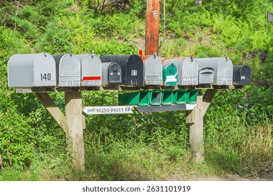 Row of mailboxes of different sizes at the roadside in rural Maine, New England, USA