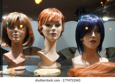 Row Of Mannequin Heads With Wigs On The Shelf. Night Scene. Mannequins With Ginger Style Wigs On Shelves Of Hair Salon 