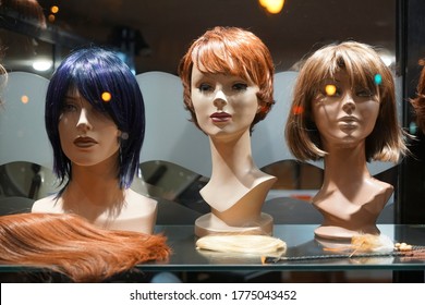 Row Of Mannequin Heads With Wigs On The Shelf. Night Scene. Mannequins With Ginger Style Wigs On Shelves Of Hair Salon 