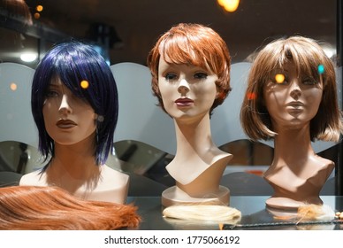 Row Of Mannequin Heads With Wigs On The Shelf. Night Scene. Mannequins With Ginger Style Wigs On Shelves Of Hair Salon 