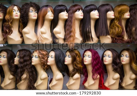 a row of mannequins on a shelf in a wig shop