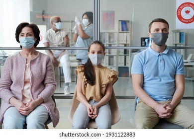 Row Of Mature Woman, Little Girl And Young Man In Protective Masks Sitting On Chairs In Clinics And Waiting For Their Turn To Have Vaccination