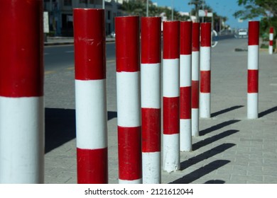 A row of mild steel bollards red and white. Traffic security and protection concept. Selected focus