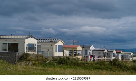 Row Of Mobile Homes In Caravan Park, Dark Cloudy Sky Background